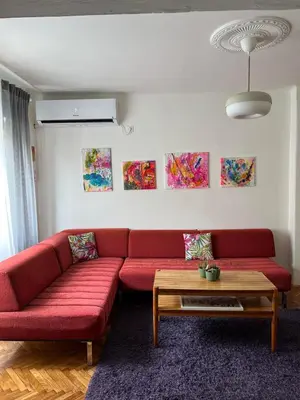 a living room with a red couch and a coffee table at Queen of the arts in Belgrade