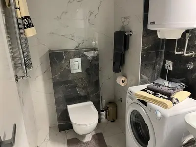 a bathroom with a toilet and a washing machine at THE FIVE-New Belgrade Apartment in Belgrade
