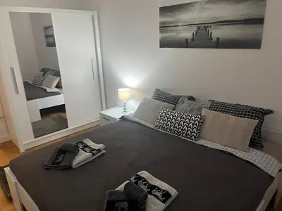 a bedroom with a large bed and a mirror at THE FIVE-New Belgrade Apartment in Belgrade