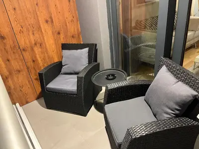 a room with two chairs and a chair and a pillow at THE FIVE-New Belgrade Apartment in Belgrade