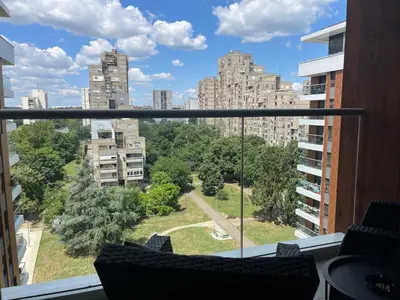 a balcony with a view of a park and buildings at THE FIVE-New Belgrade Apartment in Belgrade