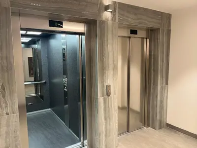 a lobby with two glass elevators in a building at THE FIVE-New Belgrade Apartment in Belgrade