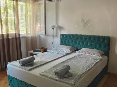 a bed with a green headboard in a bedroom at Apartman Sasha 2 in Belgrade
