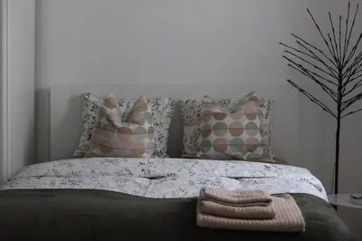 a bedroom with a bed with pillows and a tree at Apartment Mina in Belgrade