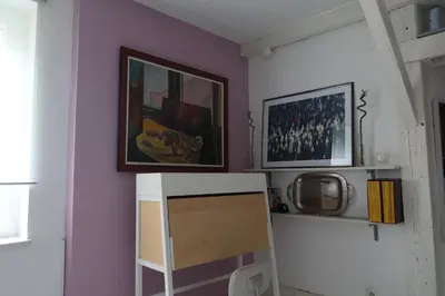 a room with a purple wall with a desk and a picture at Apartment Mina in Belgrade