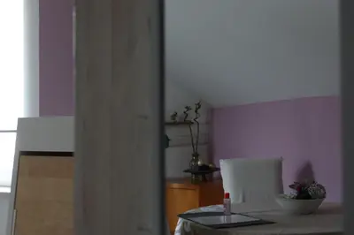 a kitchen with purple walls and a table and a chair at Apartment Mina in Belgrade