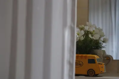 a yellow toy van with a vase of white flowers at Apartment Mina in Belgrade