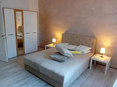 a bedroom with a bed with two tables and two lamps at Apartman centar SD in Smederevo