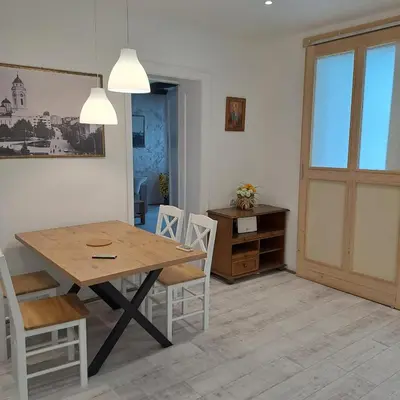 a dining room with a wooden table and chairs at Apartman centar SD in Smederevo