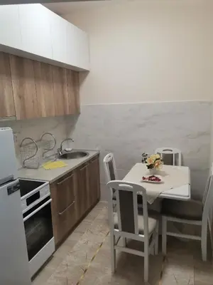 a kitchen with a sink and a table with chairs at Topli Dom Obrenovac in Obrenovac