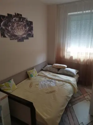 a large bed in a room with a window at Topli Dom Obrenovac in Obrenovac