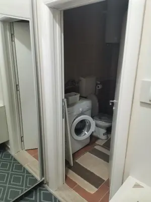 a bathroom with a toilet and a door open at Topli Dom Obrenovac in Obrenovac