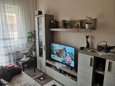 a living room with a flat screen tv in a cabinet at Topli Dom Obrenovac in Obrenovac