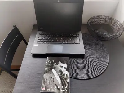 a laptop computer sitting on a table with a magazine at Apartman Elena Dedinje in Belgrade