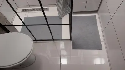 a white bathroom with a toilet and a rug at Apartman Elena Dedinje in Belgrade