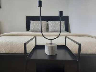 a lamp on a table in front of a bed at Apartman Elena Dedinje in Belgrade