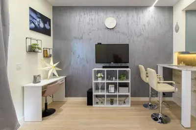 a living room with a tv and a desk and chairs at Belgrade Waterfront Residences - Beograd na vodi in Belgrade