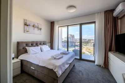 a bedroom with a bed and a large window at Belgrade Waterfront Residences - Beograd na vodi in Belgrade