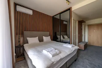 a bedroom with a large bed with two towels on it at Belgrade Waterfront Residences - Beograd na vodi in Belgrade