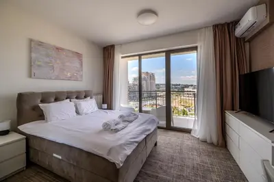 a bedroom with a bed and a large window at Belgrade Waterfront Residences - Beograd na vodi in Belgrade