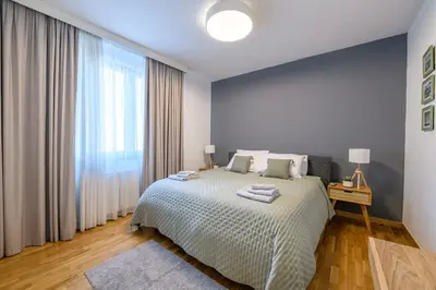 a bedroom with a bed and a large window at Belgrade Waterfront Residences - Beograd na vodi in Belgrade