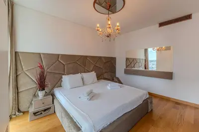a bedroom with a large bed and a chandelier at Belgrade Waterfront Residences - Beograd na vodi in Belgrade