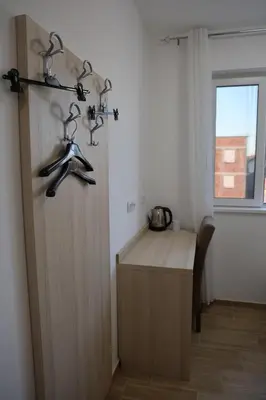 a room with a wooden cabinet with hangers on the wall at home in superior如家 in Surčin