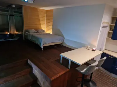 a bedroom with a bed and a table and a desk at Jacuzzi Vaki Apartment in Belgrade