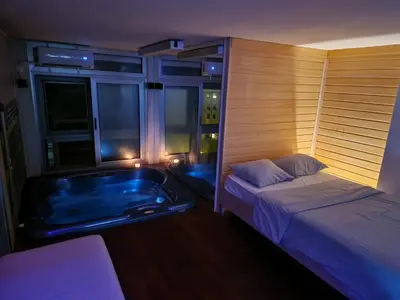 a bedroom with a bed and a tub in a room at Jacuzzi Vaki Apartment in Belgrade