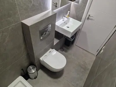 a bathroom with a white toilet and a sink at Jacuzzi Vaki Apartment in Belgrade
