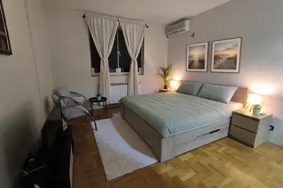 a bedroom with a bed and a window at Apartman Quality in Voždovac