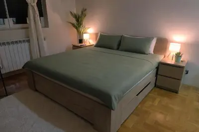 a bedroom with a large bed with two night stands at Apartman Quality in Voždovac