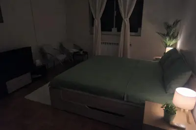 a bedroom with a green bed and a couch at Apartman Quality in Voždovac