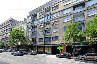 a building on a street with cars parked in front of it at Vintage Dream Apartment in Belgrade
