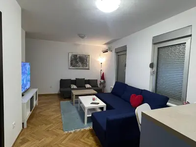 a living room with a blue couch and a table at Lovely flat in Vračar (historical)