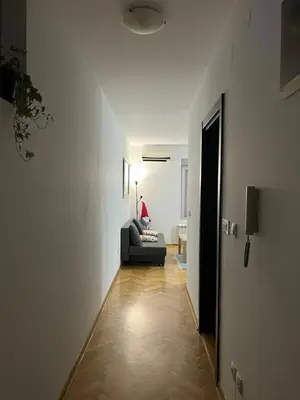 a living room with a couch and a person sitting on a chair at Lovely flat in Vračar (historical)