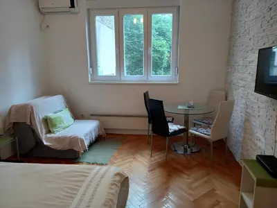 a room with a bed and a table and a window at Sofija 1 in Vračar (historical)