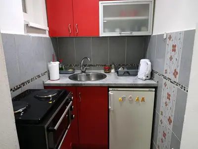 a small kitchen with red cabinets and a sink at Sofija 1 in Vračar (historical)