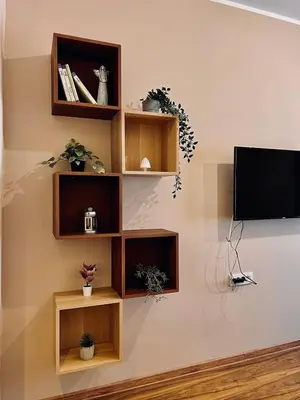 a wall with wooden shelves and a flat screen tv at Old Gold Downtown Belgrade in Belgrade