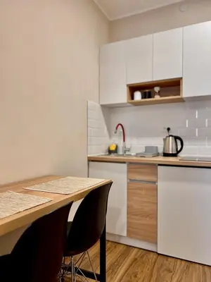 a kitchen with white cabinets and a wooden table at Old Gold Downtown Belgrade in Belgrade