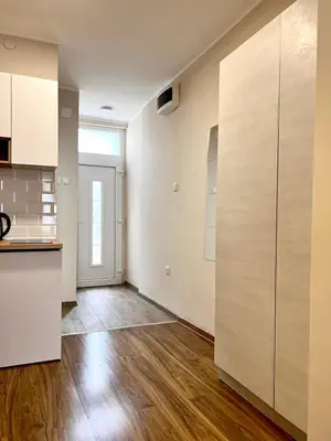 a kitchen with white cabinets and a hard wood floor at Old Gold Downtown Belgrade in Belgrade