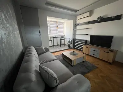 a living room with a couch and a tv at Central Sky View Apartment in Belgrade
