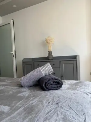 a gray towel on a bed in a bedroom at Central Sky View Apartment in Belgrade