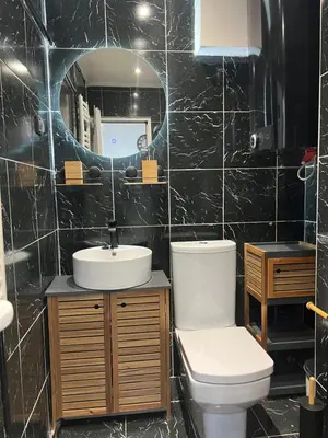 a bathroom with a toilet and a sink and a mirror at Central Sky View Apartment in Belgrade