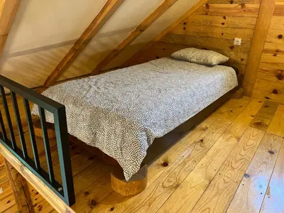 a bed in a attic with a wooden floor at Vikendica Milošević in Arandjelovac