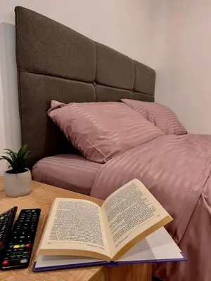 an open book on a table next to a bed at Stone House Central Belgrade Studio in Belgrade