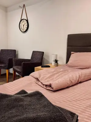 a bedroom with a bed and a clock on the wall at Stone House Central Belgrade Studio in Belgrade
