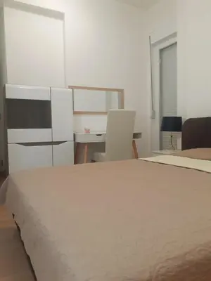 a white bedroom with a bed and a desk at Beograd /Slavija - fontana 70 m2 in Sajmište