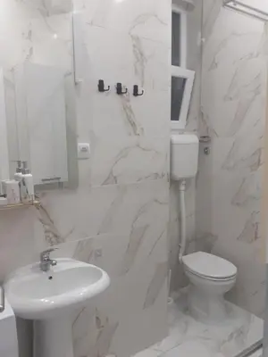 a white bathroom with a toilet and a sink at Beograd /Slavija - fontana 70 m2 in Sajmište