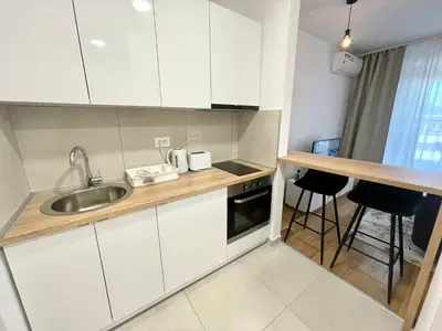a kitchen with white cabinets and a sink at Green - stan na dan studio Novi Beograd, parking 5 evra dan in Belgrade